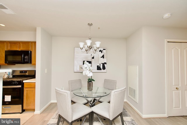 dining room featuring light hardwood / wood-style flooring and a chandelier