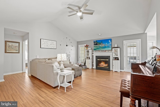 living room with light wood-type flooring, lofted ceiling, and ceiling fan