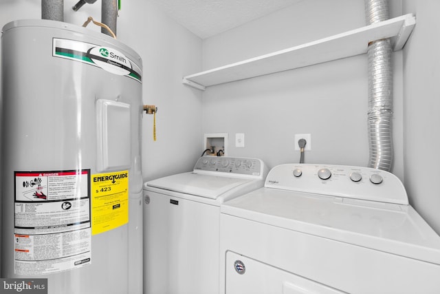 washroom featuring independent washer and dryer, water heater, and a textured ceiling