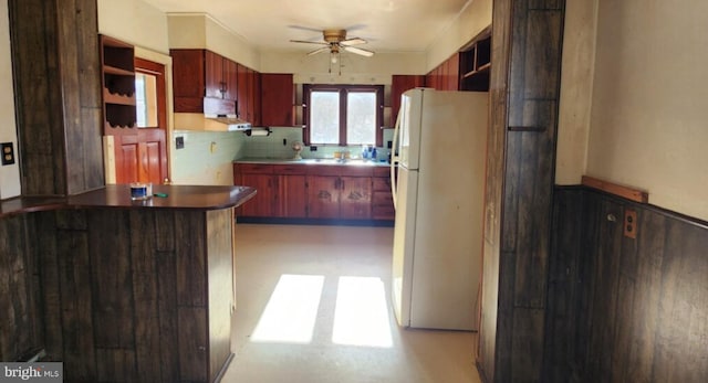 kitchen featuring tasteful backsplash, ceiling fan, kitchen peninsula, and white fridge