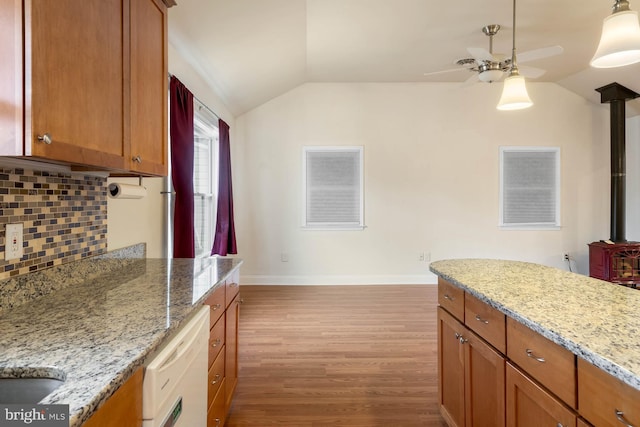 kitchen featuring white dishwasher, decorative backsplash, vaulted ceiling, and wood finished floors