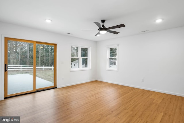 spare room featuring ceiling fan, light wood finished floors, visible vents, and baseboards