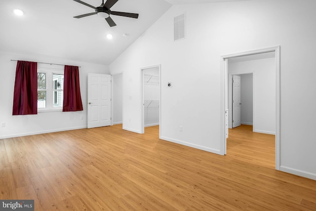 unfurnished bedroom featuring baseboards, high vaulted ceiling, visible vents, and light wood-style floors