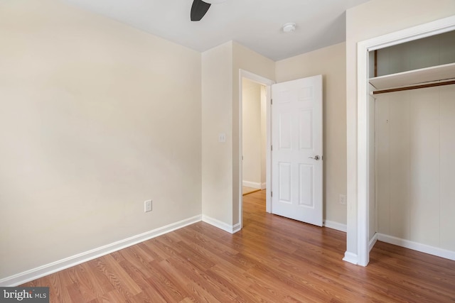 unfurnished bedroom with light wood-style floors, a ceiling fan, baseboards, and a closet