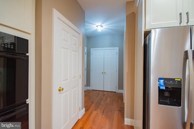 hallway with light wood-style flooring and baseboards