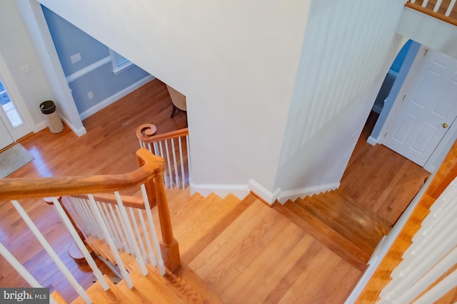 staircase with baseboards and wood finished floors