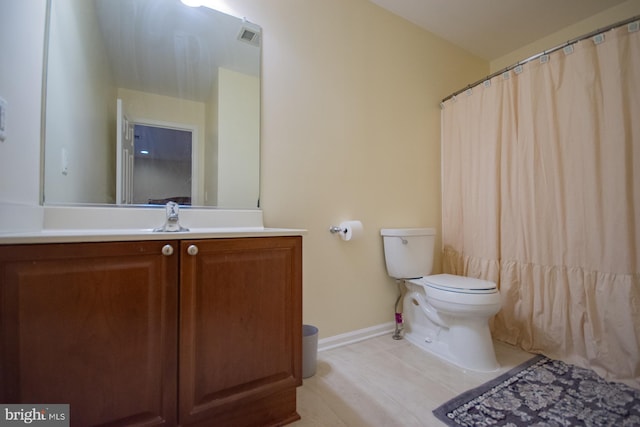 full bath with visible vents, vanity, toilet, and baseboards