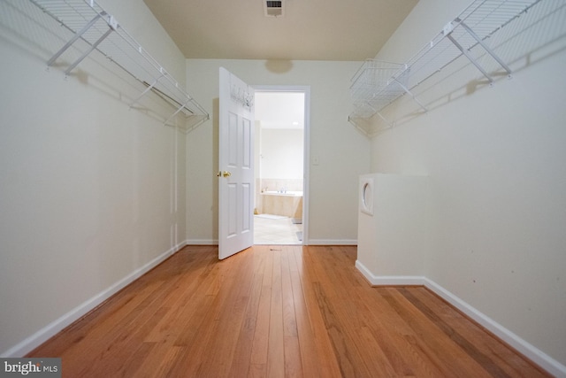 walk in closet with light wood finished floors and visible vents