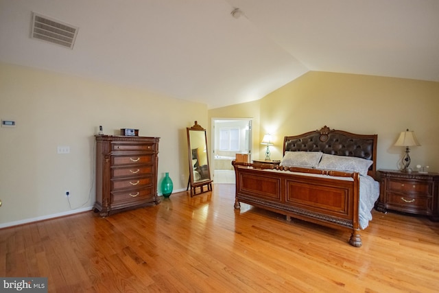 bedroom featuring lofted ceiling, light wood finished floors, baseboards, and visible vents