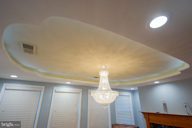 details featuring visible vents, a raised ceiling, and recessed lighting