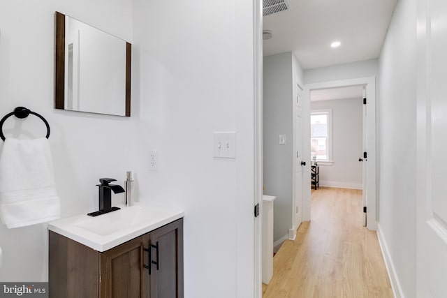 hall with sink and light wood-type flooring