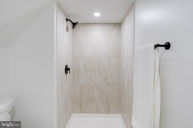 bathroom featuring toilet and a tile shower