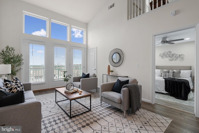 living room with ceiling fan, hardwood / wood-style floors, and high vaulted ceiling