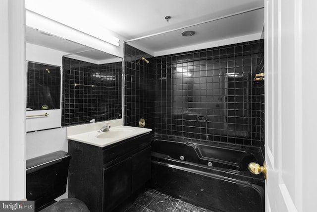 full bathroom with tiled shower / bath, vanity, and toilet