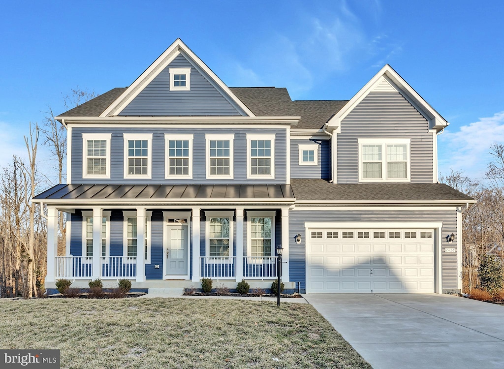 view of front of property featuring a shingled roof, covered porch, driveway, and a standing seam roof