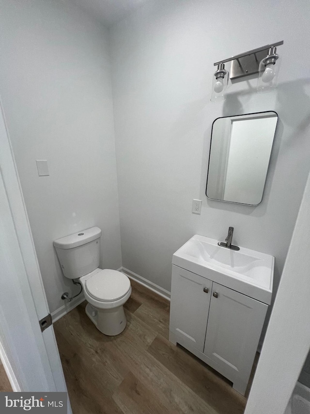 bathroom with hardwood / wood-style flooring, vanity, and toilet