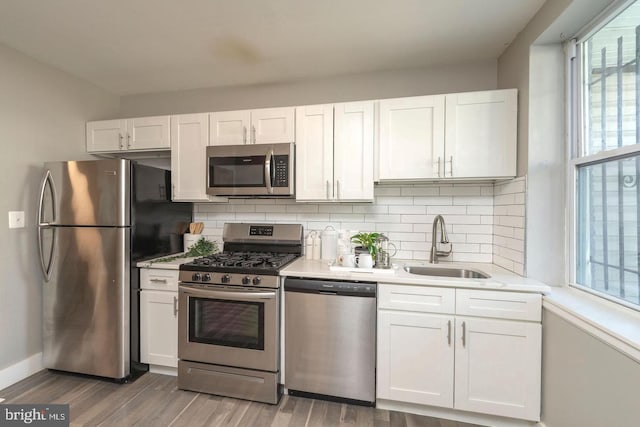 kitchen featuring white cabinetry, appliances with stainless steel finishes, sink, and tasteful backsplash