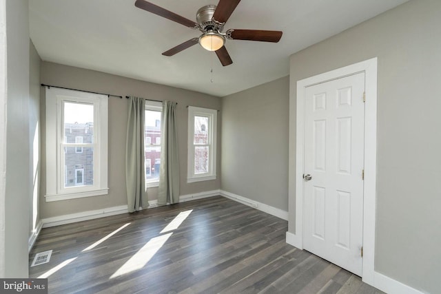 spare room with ceiling fan and dark hardwood / wood-style flooring