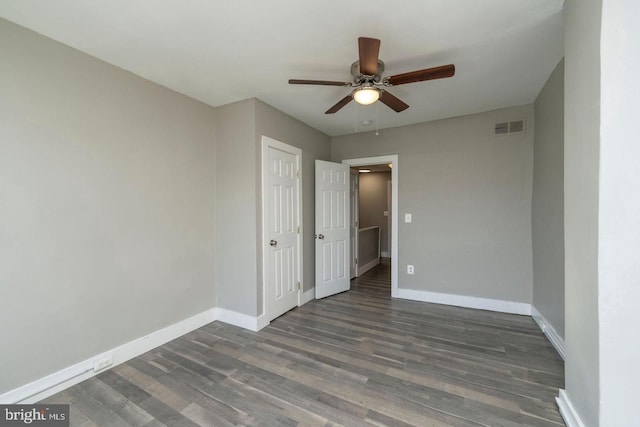 empty room with ceiling fan and dark hardwood / wood-style flooring