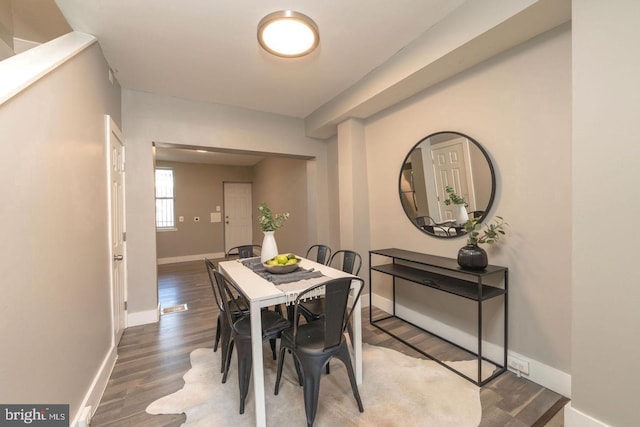 dining area featuring dark wood-type flooring