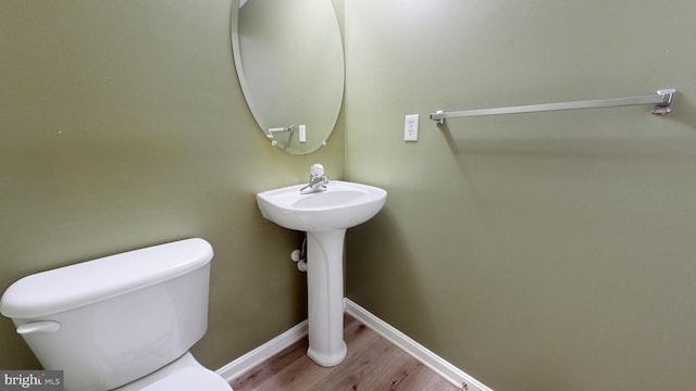 bathroom with hardwood / wood-style flooring and toilet