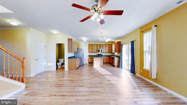 kitchen with a center island, hanging light fixtures, light hardwood / wood-style flooring, stainless steel appliances, and ceiling fan with notable chandelier