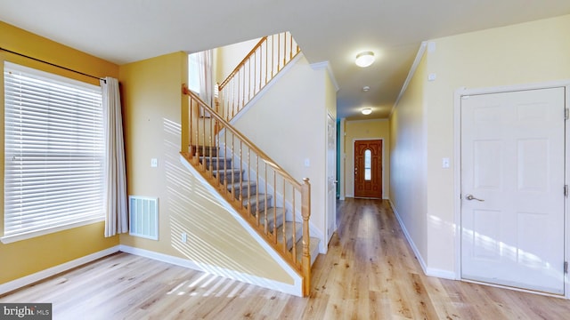 foyer entrance featuring ornamental molding and light hardwood / wood-style floors