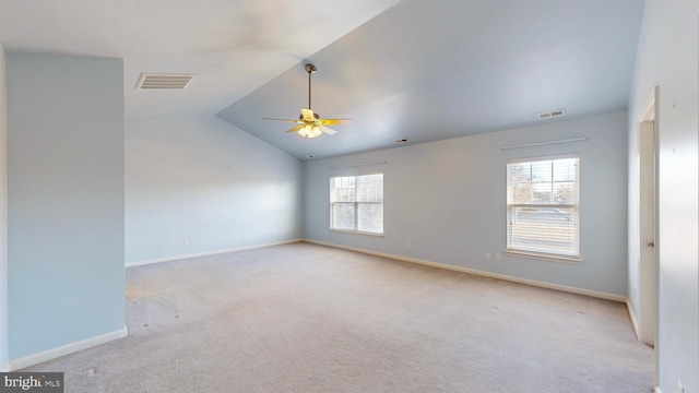 carpeted empty room with vaulted ceiling and ceiling fan