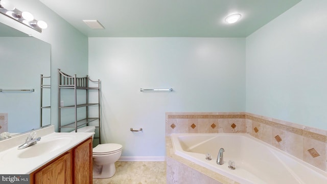 bathroom featuring tile patterned flooring, vanity, tiled bath, and toilet