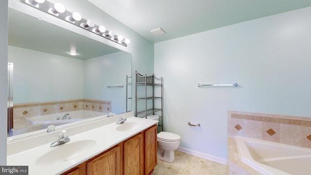 bathroom featuring vanity, tiled tub, tile patterned floors, and toilet