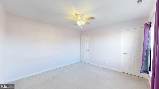 empty room featuring ceiling fan and light colored carpet