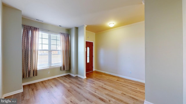 foyer entrance featuring ornamental molding and light hardwood / wood-style floors