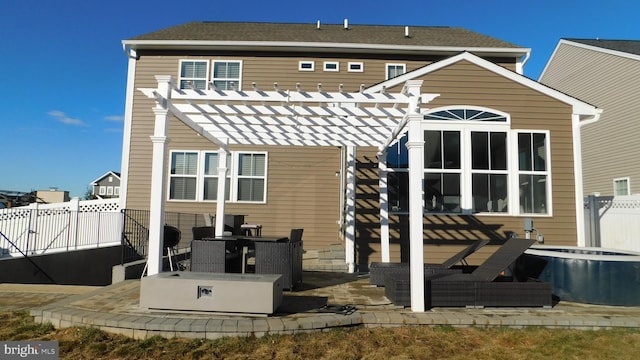 rear view of property featuring a patio and a pergola