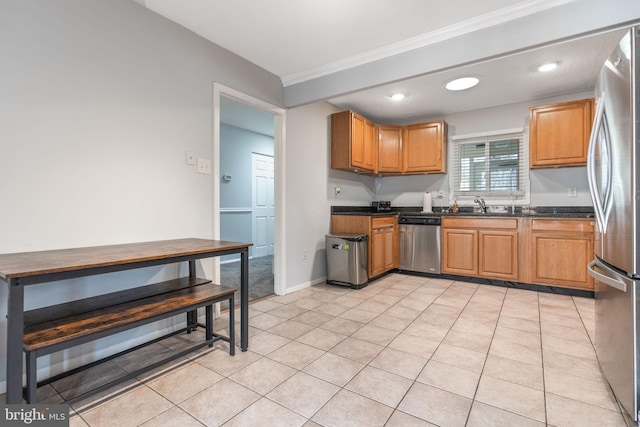 kitchen with appliances with stainless steel finishes, sink, light tile patterned floors, and dark stone counters