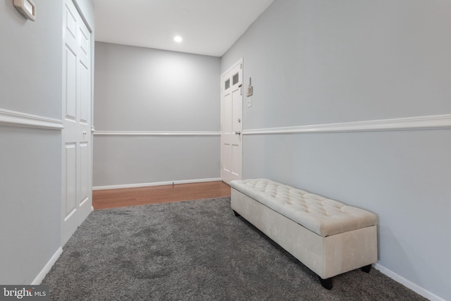 sitting room featuring dark carpet