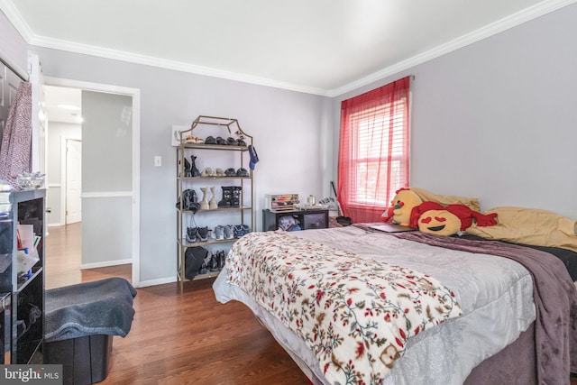 bedroom featuring a fireplace, ornamental molding, and dark hardwood / wood-style floors