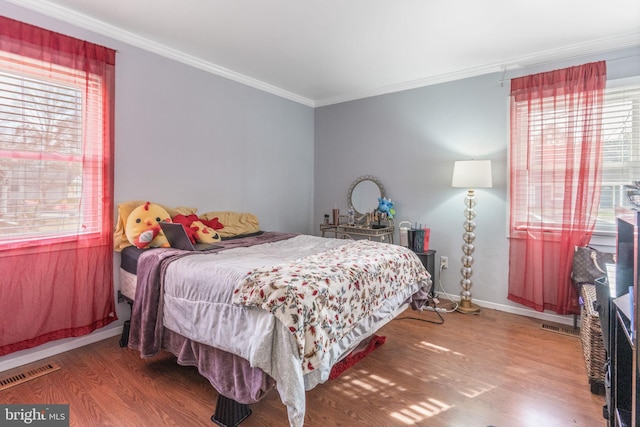 bedroom featuring wood-type flooring and crown molding