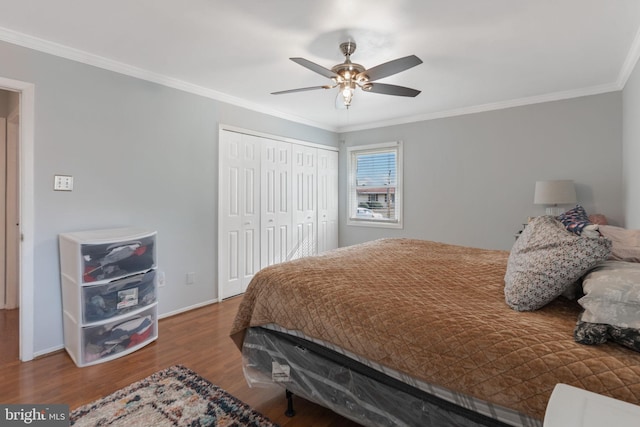 bedroom featuring hardwood / wood-style flooring, ceiling fan, crown molding, and a closet