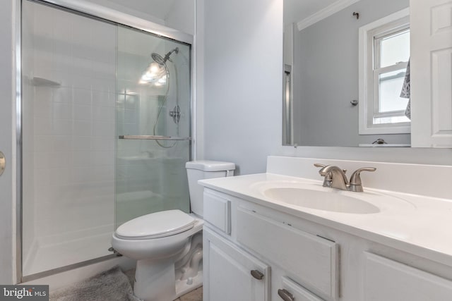 bathroom featuring crown molding, vanity, toilet, and an enclosed shower