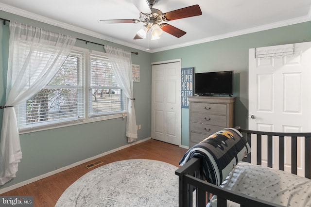 bedroom featuring crown molding, ceiling fan, light hardwood / wood-style floors, and a closet