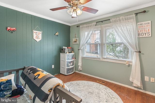 bedroom featuring crown molding, ceiling fan, and wood-type flooring