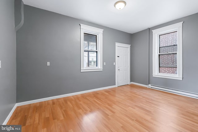 spare room with light hardwood / wood-style floors and a baseboard heating unit