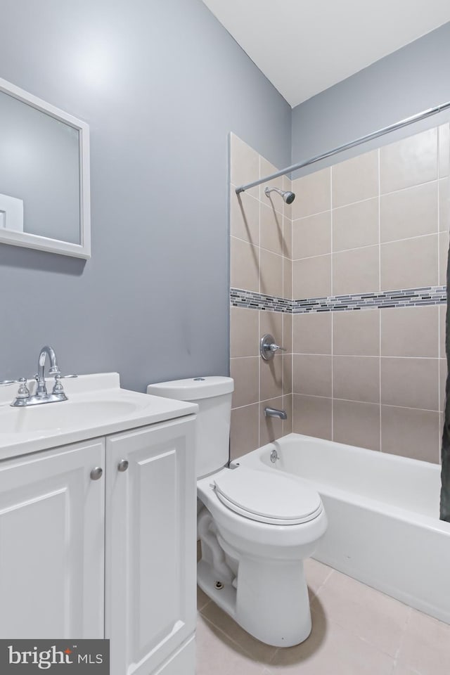 full bathroom with tiled shower / bath, toilet, tile patterned floors, and vanity