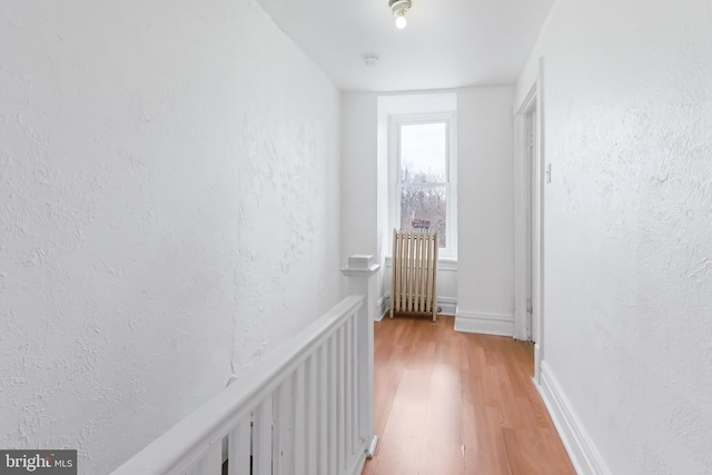 hall with radiator heating unit and light wood-type flooring