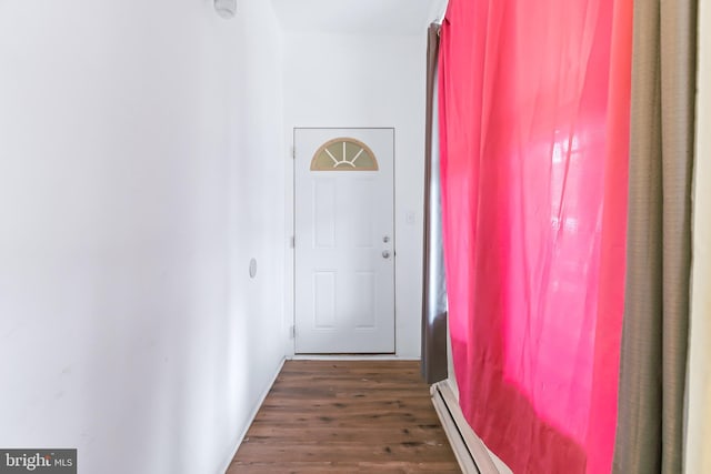 hall featuring dark wood-type flooring and a baseboard heating unit