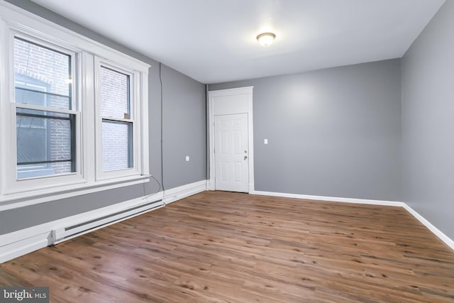 unfurnished room featuring a baseboard radiator and hardwood / wood-style floors