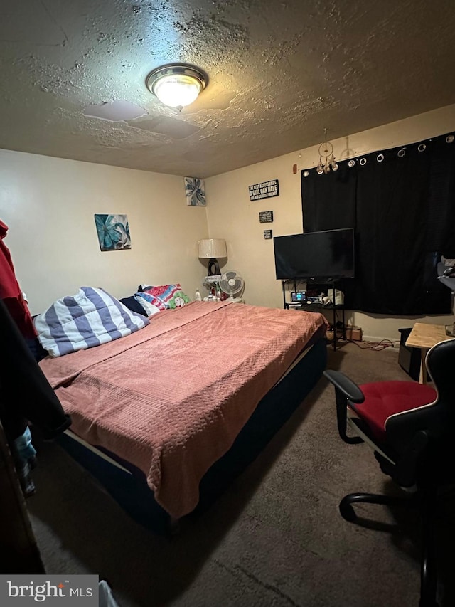 bedroom featuring carpet floors and a textured ceiling