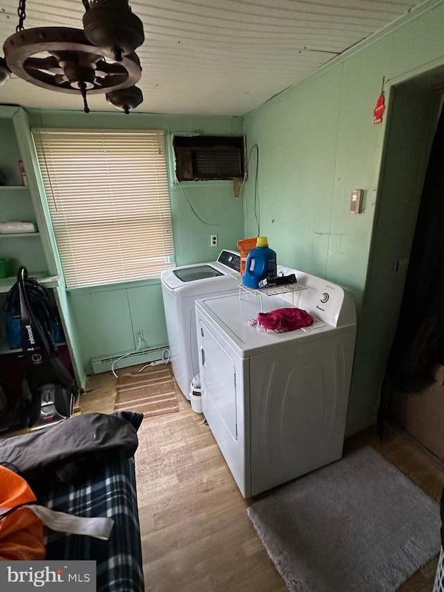 washroom with a baseboard radiator, washer and dryer, and light wood-type flooring