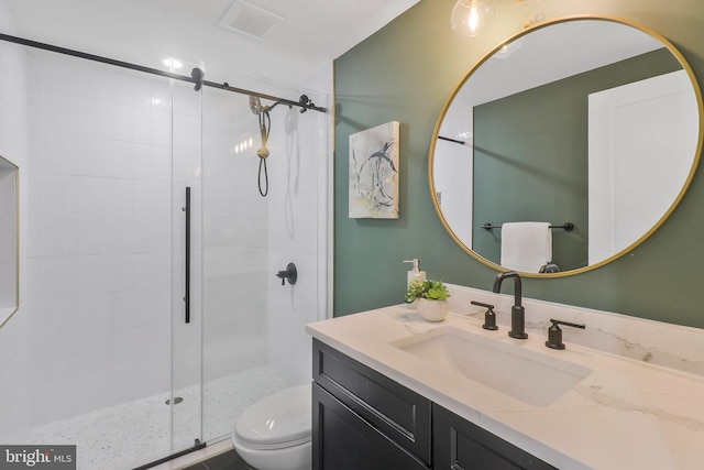 bathroom featuring walk in shower, vanity, and toilet