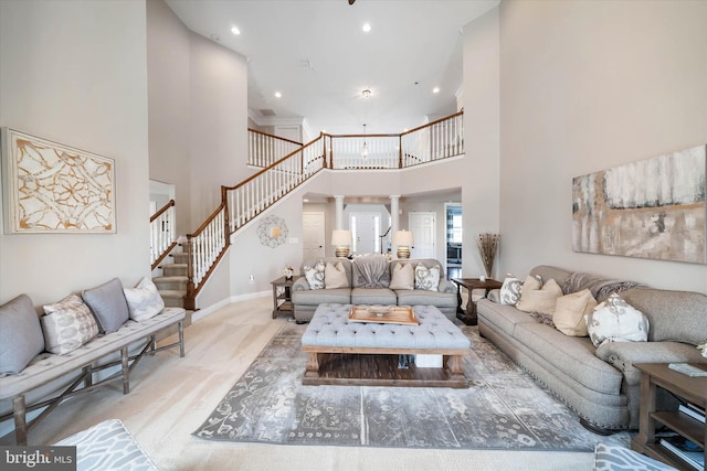 living room with a towering ceiling and decorative columns